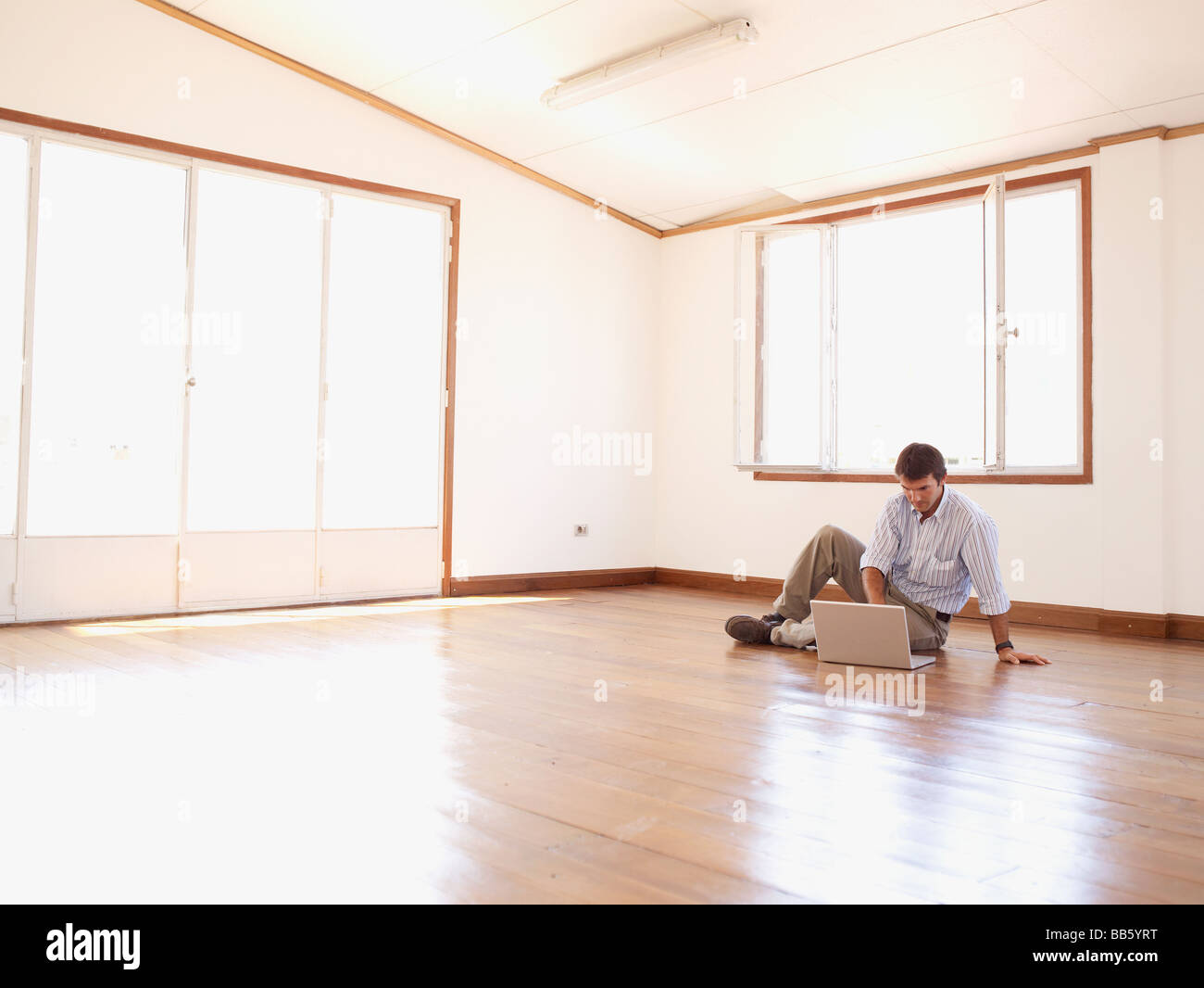 Hispanic businessman using laptop in empty office Banque D'Images