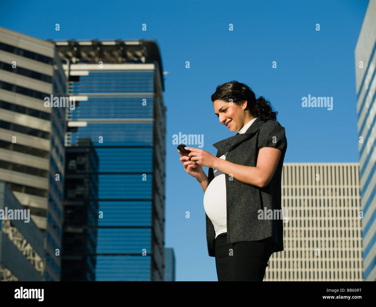 Pregnant Middle Eastern woman using cell phone Banque D'Images