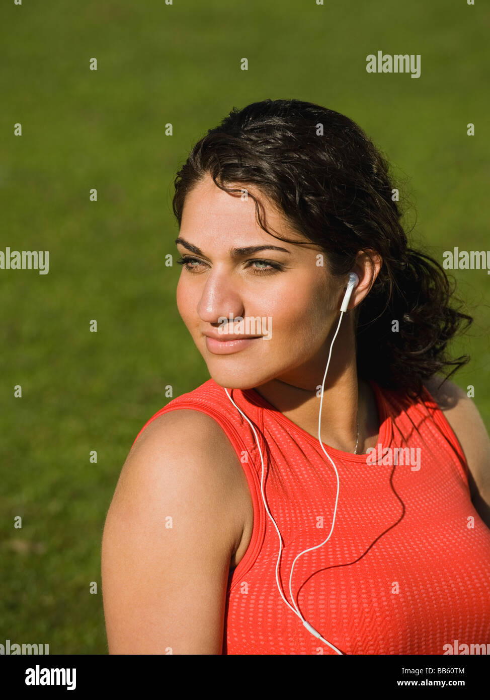 Middle Eastern woman listening to music in park Banque D'Images