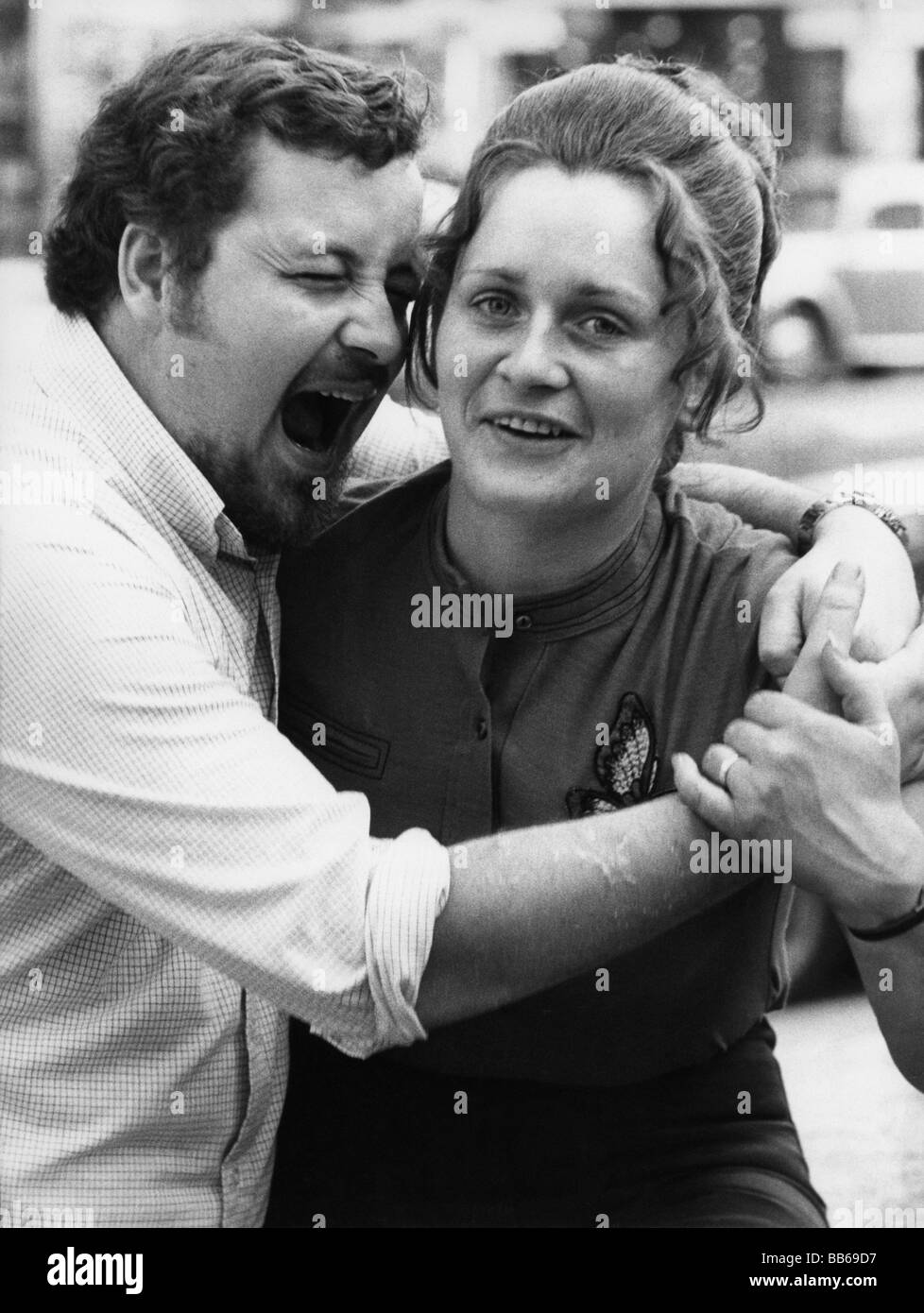 Oddity, homme riant dans l'oreille de sa femme, juin 1971, Banque D'Images