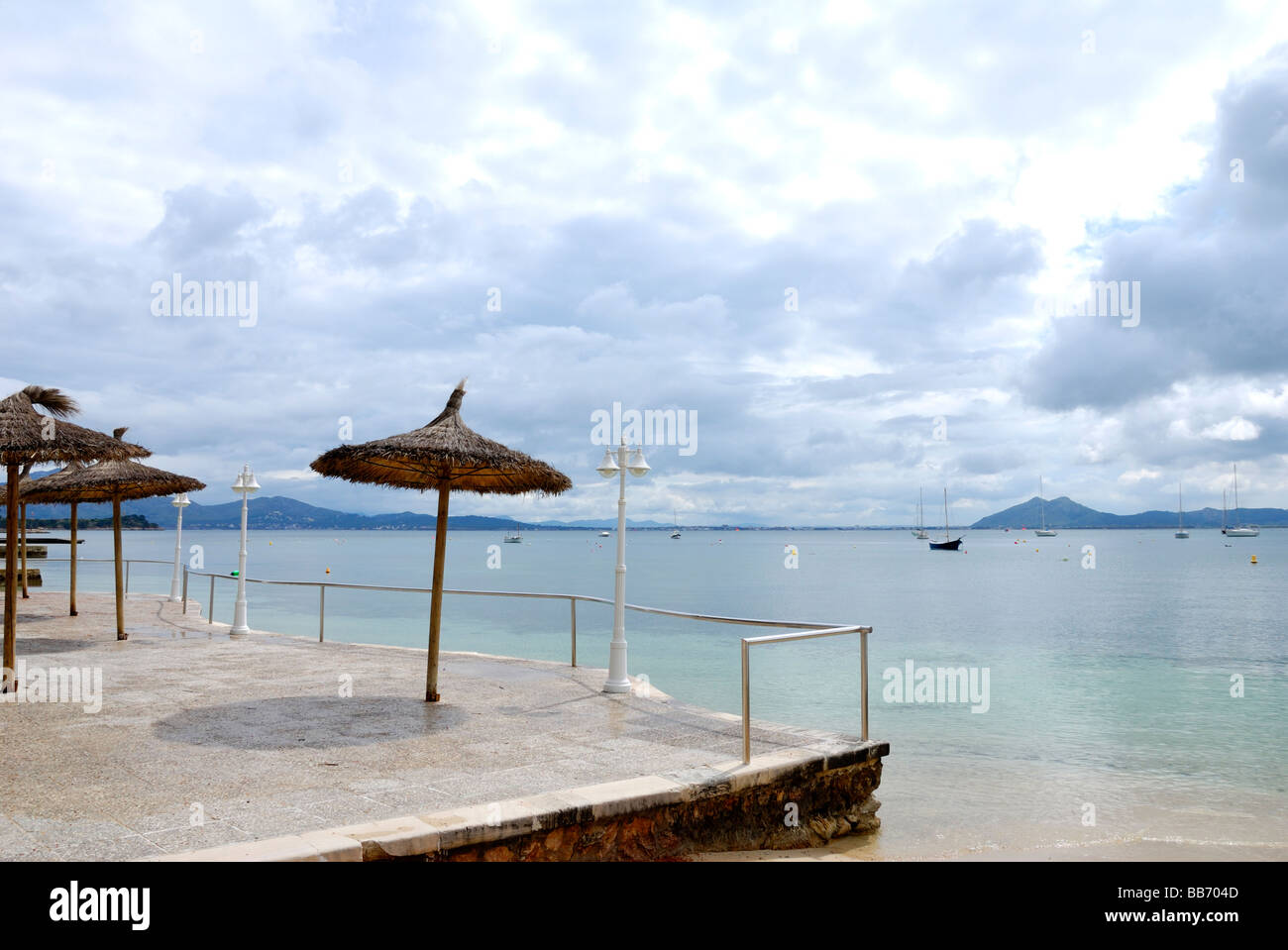 Des parasols de paille à la recherche sur la baie de Pollensa Banque D'Images