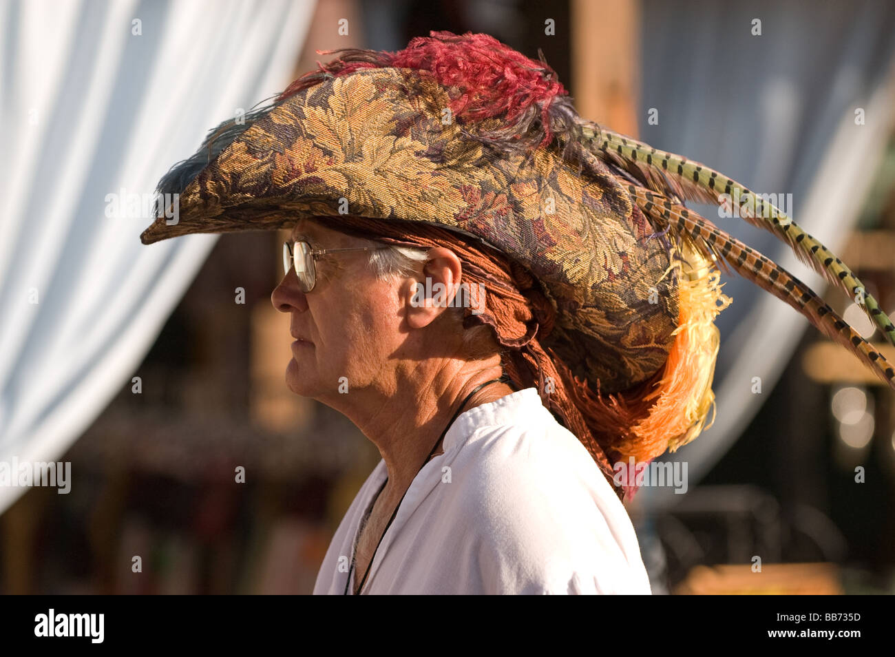 Un homme marche dans la rue portant un grand chapeau à plume à la  Renaissance faire plaisir Photo Stock - Alamy