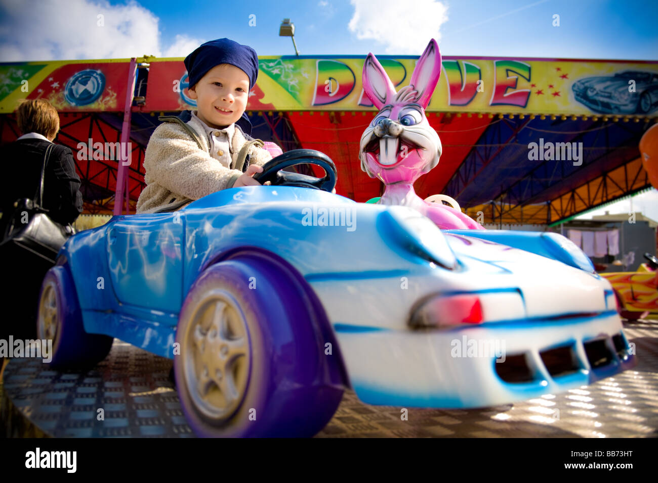 Boy (4-5) en voiture en plastique à des expositions Banque D'Images