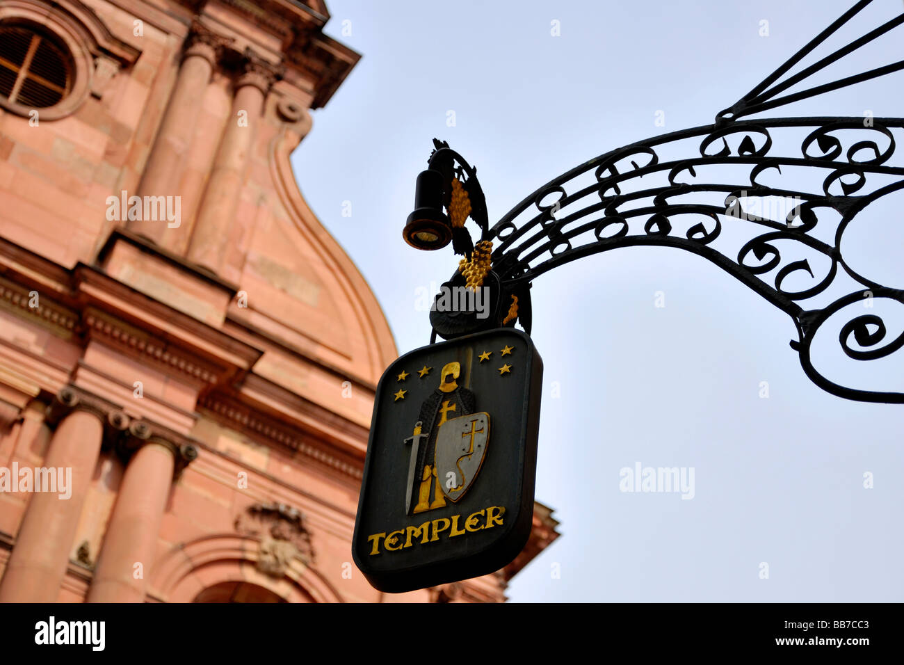 Restaurant sign et de la ferronnerie avec la figure d'un chevalier avec une vieille église européenne floue dans l'arrière-plan Banque D'Images