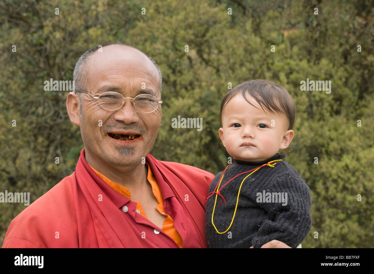 Man eating bétel, avec le petit-enfant, le Bhoutan Banque D'Images