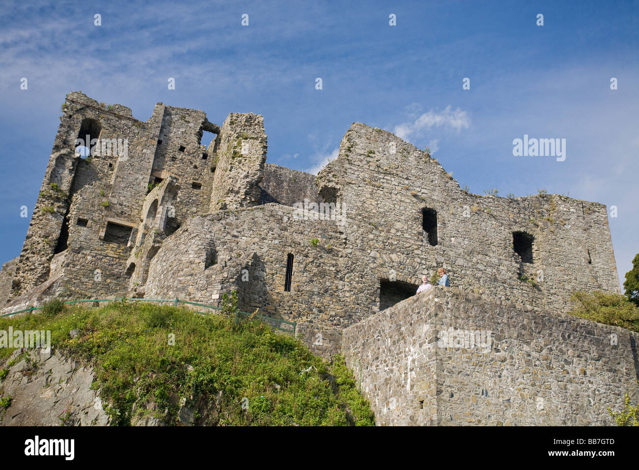 Château du Roi Jean. Deux touristes sont éclipsées par la ruine massive des murs en pierre de cet ancien château irlandais. Banque D'Images