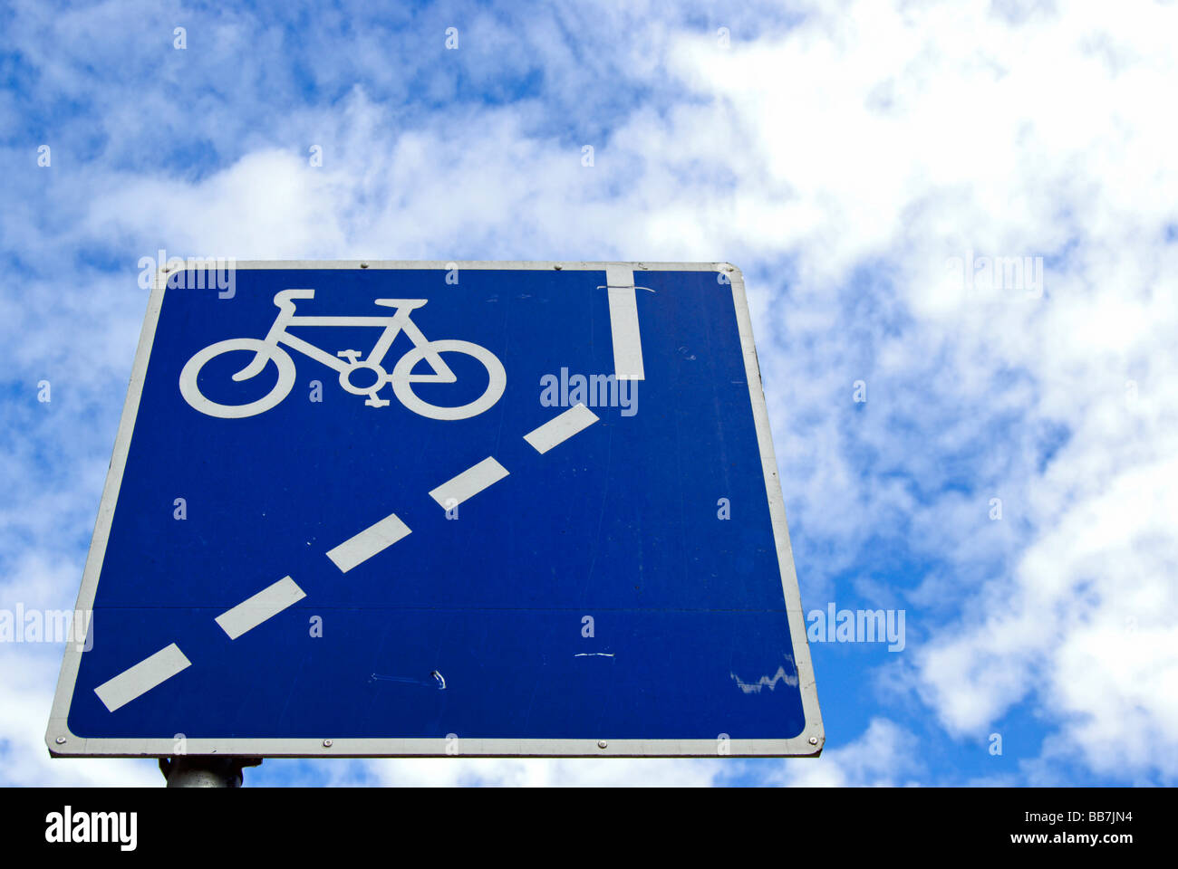 Vu sous un ciel moucheté de nuages cirrocumulus patch work bleu et blanc en signe de route indiquant la voie à venir cycle obligatoire Banque D'Images Vu sous un ciel moucheté de nuages cirrocumulus patch work bleu et blanc en signe de route indiquant la voie à venir cycle obligatoire Banque D'Images