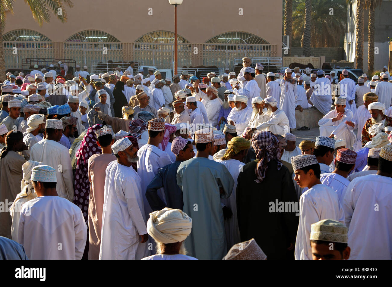 Scène de foule sur un marché au bétail, les hommes omanais portant un costume national Dishdasha et une cape ou une Kummah Mussar turban sur la tête Banque D'Images