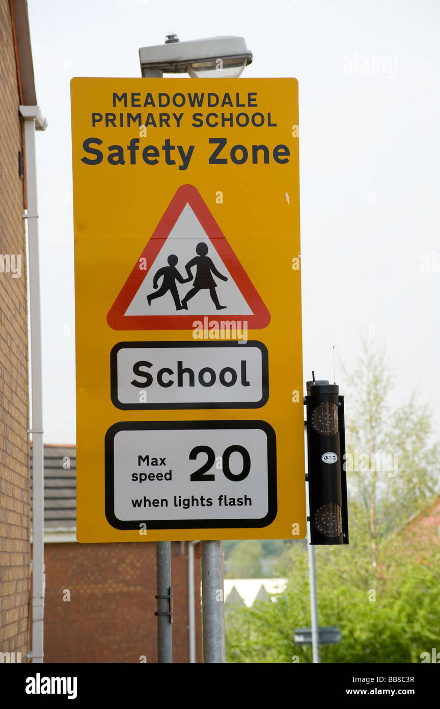 Panneau jaune indiquant une limite de vitesse de 20 miles par heure à l'école fois dans une zone de sécurité à l'extérieur de l'école Banque D'Images
