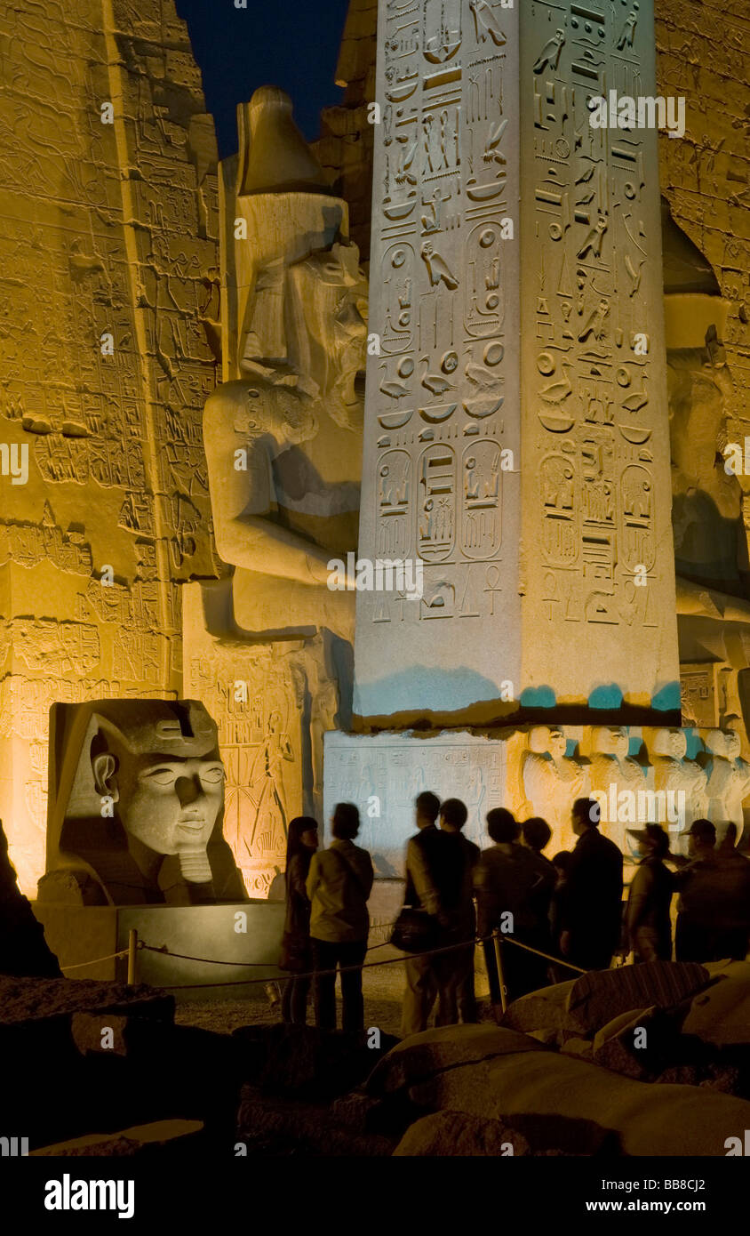 Assis avec pylône chiffres et obélisque de Ramsès II de lumière le soir, tête de Ramsès II à l'avant, le temple de Louxor Banque D'Images