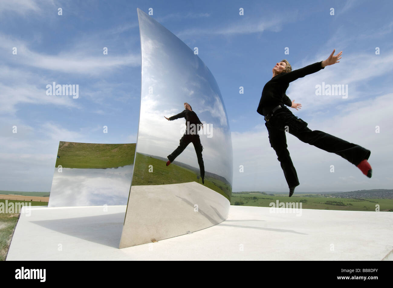 Guide Festival Helen Goodwin bondit en face de Courbe C le contre-batteur énorme miroir en acier inoxydable installation par Anish Kapoor Banque D'Images