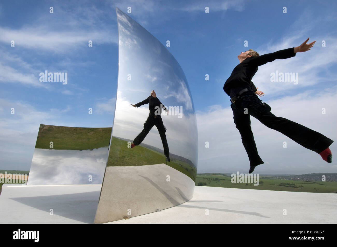 Guide Festival Helen Goodwin bondit en face de Courbe C le contre-batteur énorme miroir en acier inoxydable installation par Anish Kapoor Banque D'Images