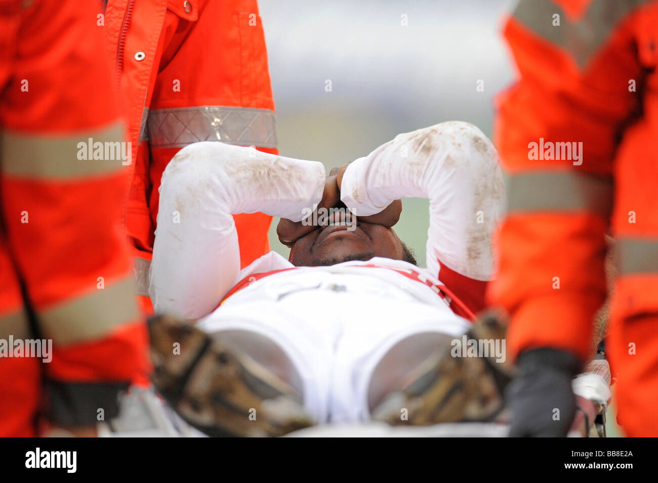 Arthur Boka, joueur de football, le VfB Stuttgart, menées sur le terrain sur une civière par le personnel paramédical Banque D'Images