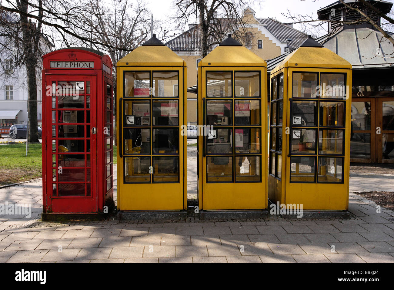 Anglais 1 rouge et 3 Jaune allemand des cabines téléphoniques dans une rangée Traunstein Bavaria Allemagne Banque D'Images