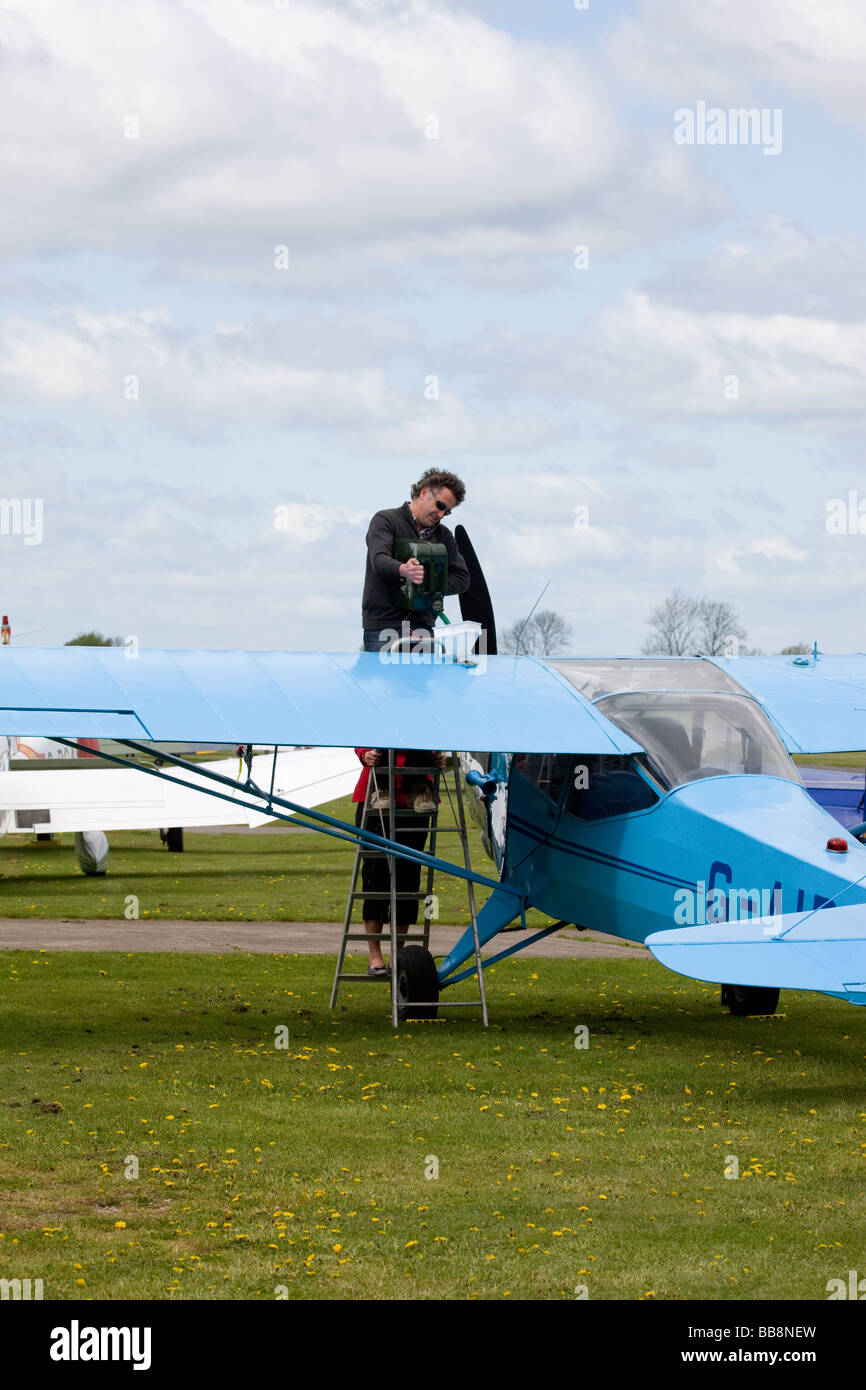 Auster JiN G-AIBW Alpha être ravitaillé de bidon par pilote à Breighton Airfield Banque D'Images