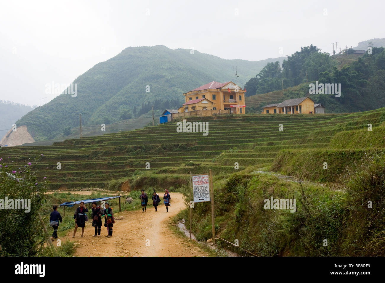 Filles Hmong noir marche à travers le village lao Chai à Sapa, Vietnam du Nord Ouest Banque D'Images