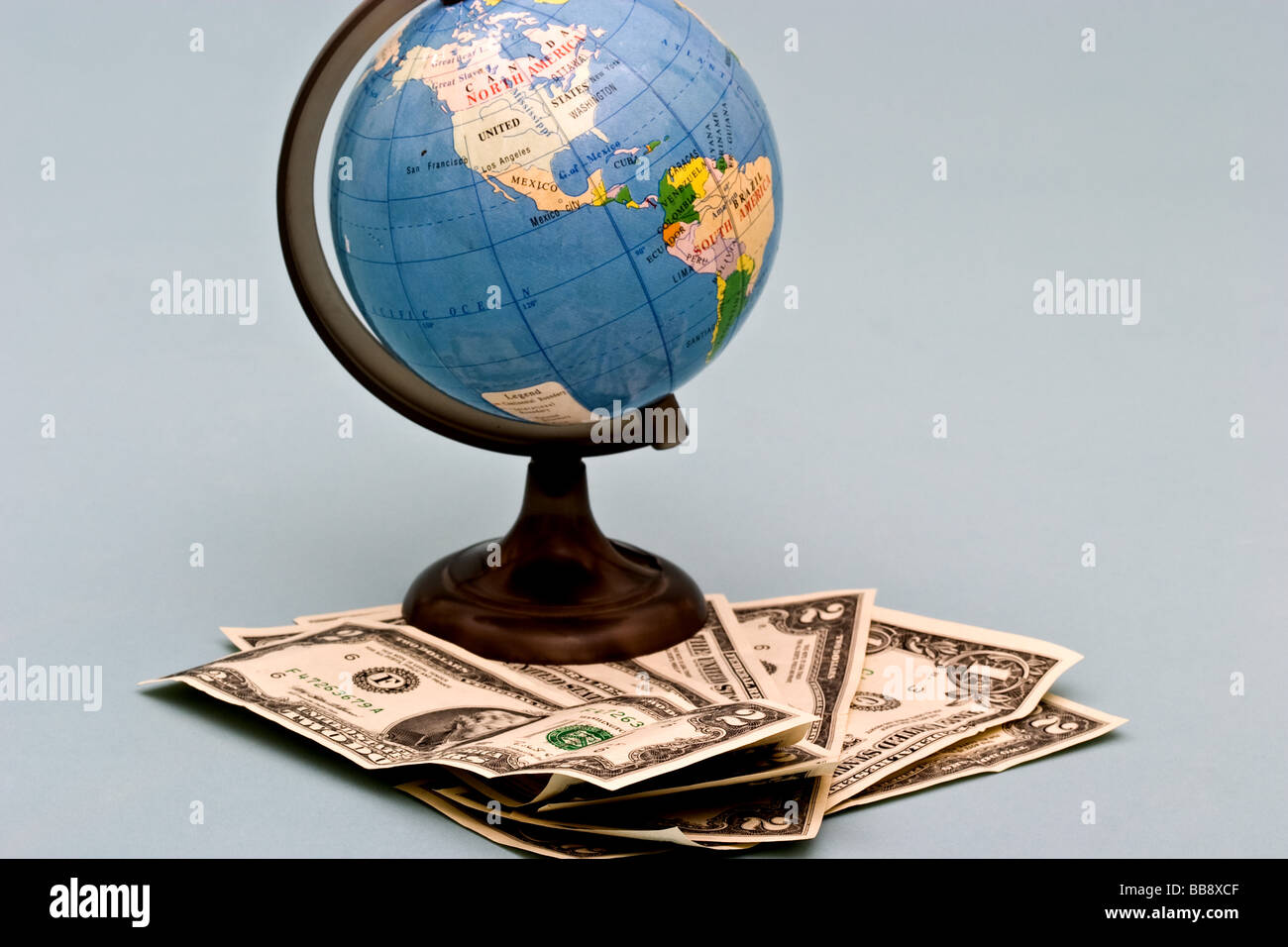 Petit globe en plastique sur une pile de papier monnaie américain Banque D'Images