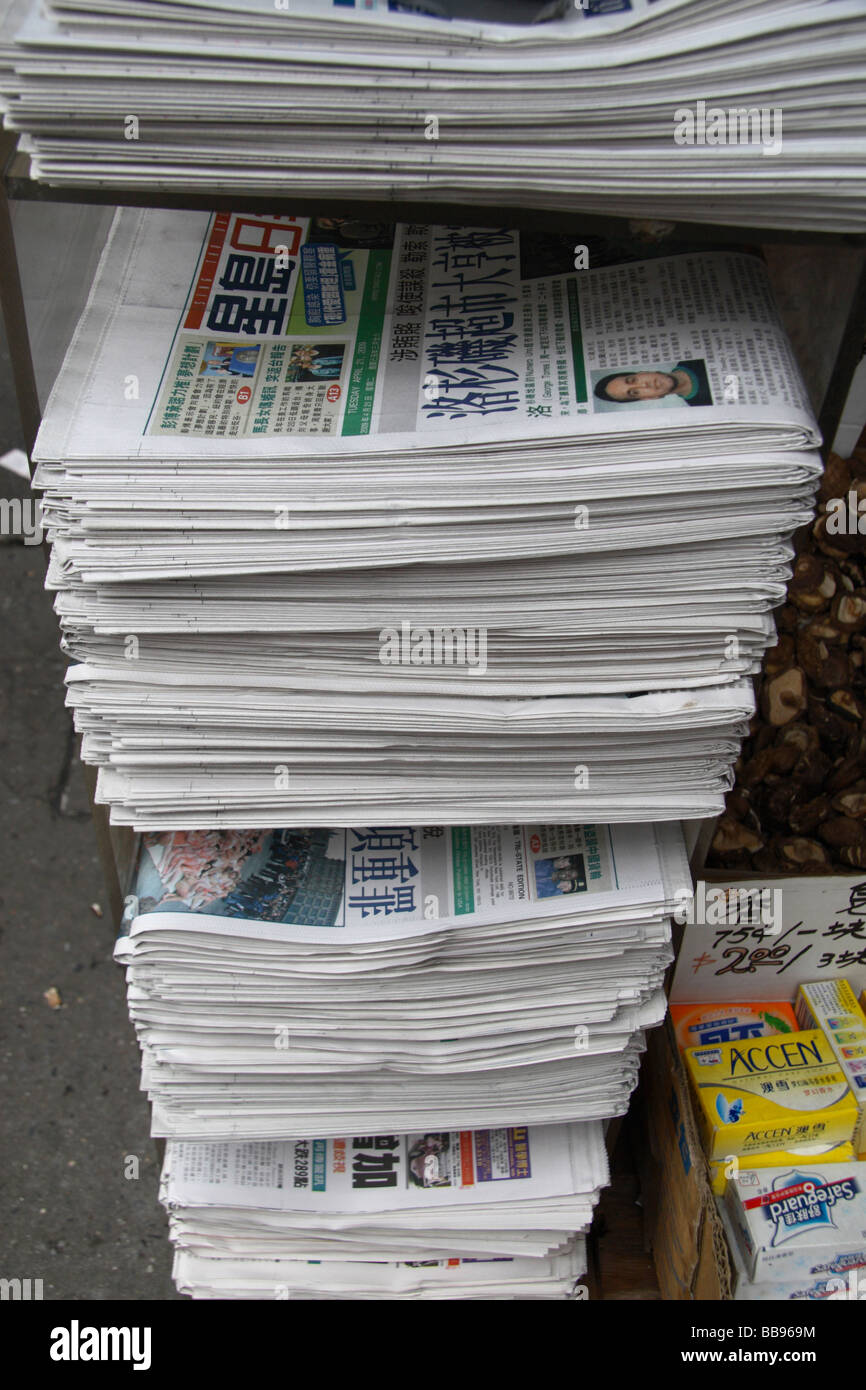 Un rack de journaux en langue étrangère sur l'affichage à un kiosque à journaux dans Chinatown, New York. Banque D'Images