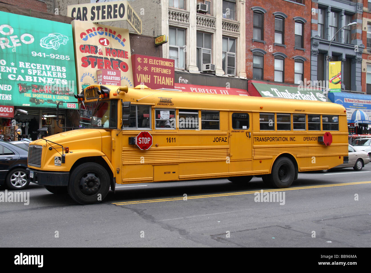Un autobus scolaire jaune en passant par Chinatown, New York. Banque D'Images