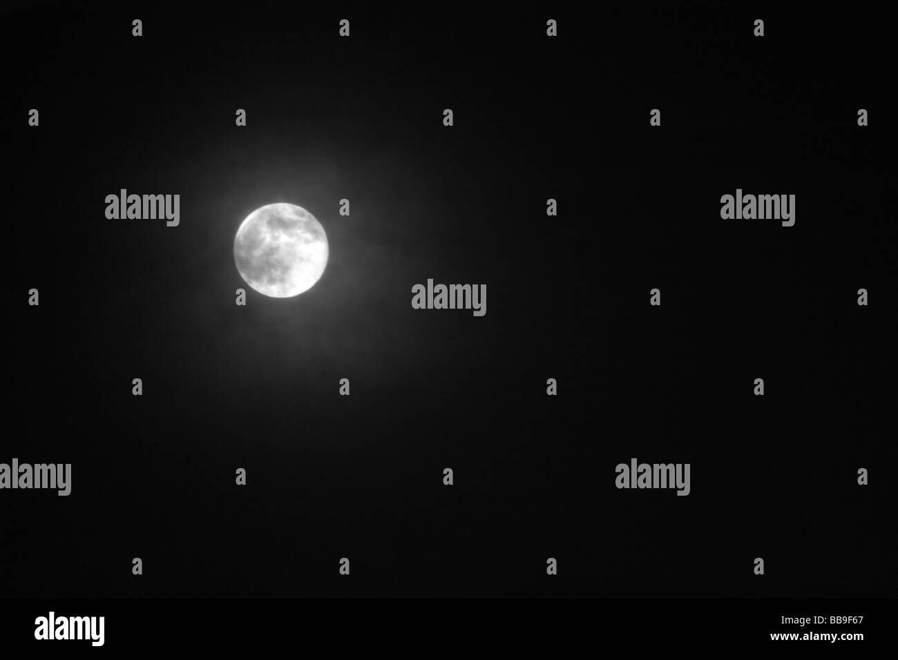 Une photographie d'une pleine lune dans la nuit avec la couverture nuageuse Banque D'Images