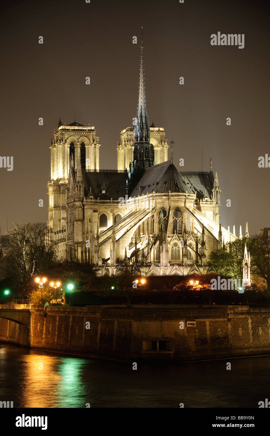 Cathédrale notre-Dame architecture gothique la nuit Paris France // PARIS, France — la cathédrale notre-Dame, un exemple important de l'architecture gothique française, est illuminée la nuit sur l'Île de la Cité. Cette cathédrale catholique historique de Paris est réputée pour ses sculptures en pierre complexes, ses impressionnants vitraux et ses contreforts volants distinctifs. La construction a commencé en 1163, et a été en grande partie achevée en 1345, ce qui en fait l'une des premières cathédrales gothiques. La flèche de la cathédrale, reconstruite après l'incendie de 2019, s'élève bien au-dessus de sa structure. Sa façade éclairée est réfléchie Banque D'Images