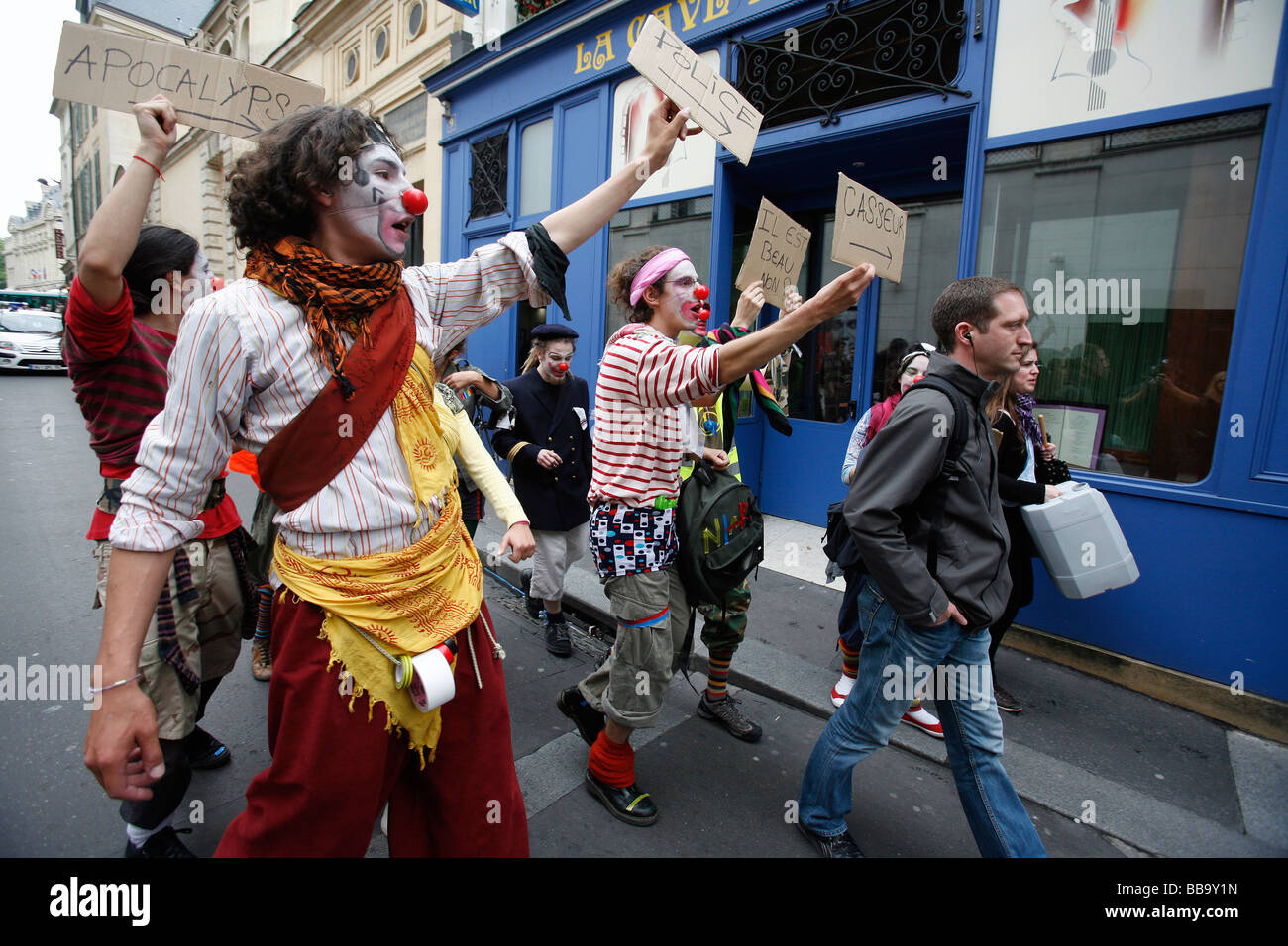 Les étudiants de l'université habillés en clowns suivent un policier en civil lors d'une manifestation de rue, Paris Banque D'Images