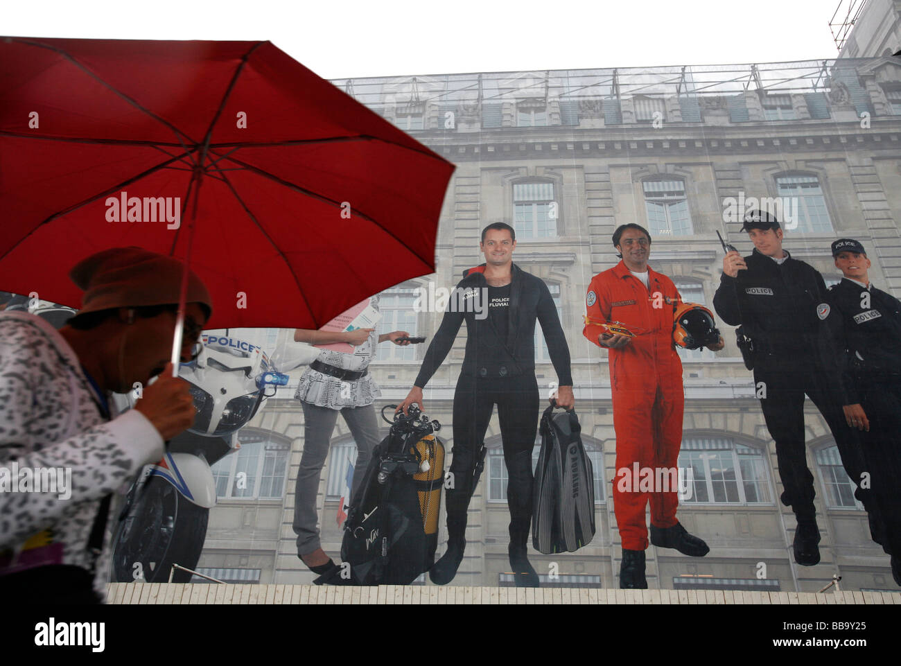 Une femme passe devant une peinture murale qui couvre la Préfecture de Police pendant les réparations à l'immeuble, Paris Banque D'Images