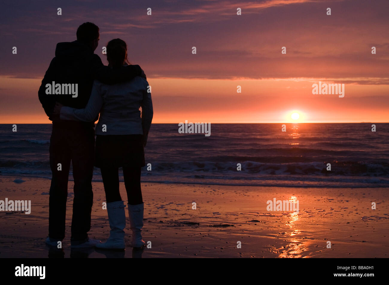 Chaque couple d'autres, regardant le coucher du soleil à partir de la plage de Scheveningen, Den Haag, Pays-Bas Banque D'Images