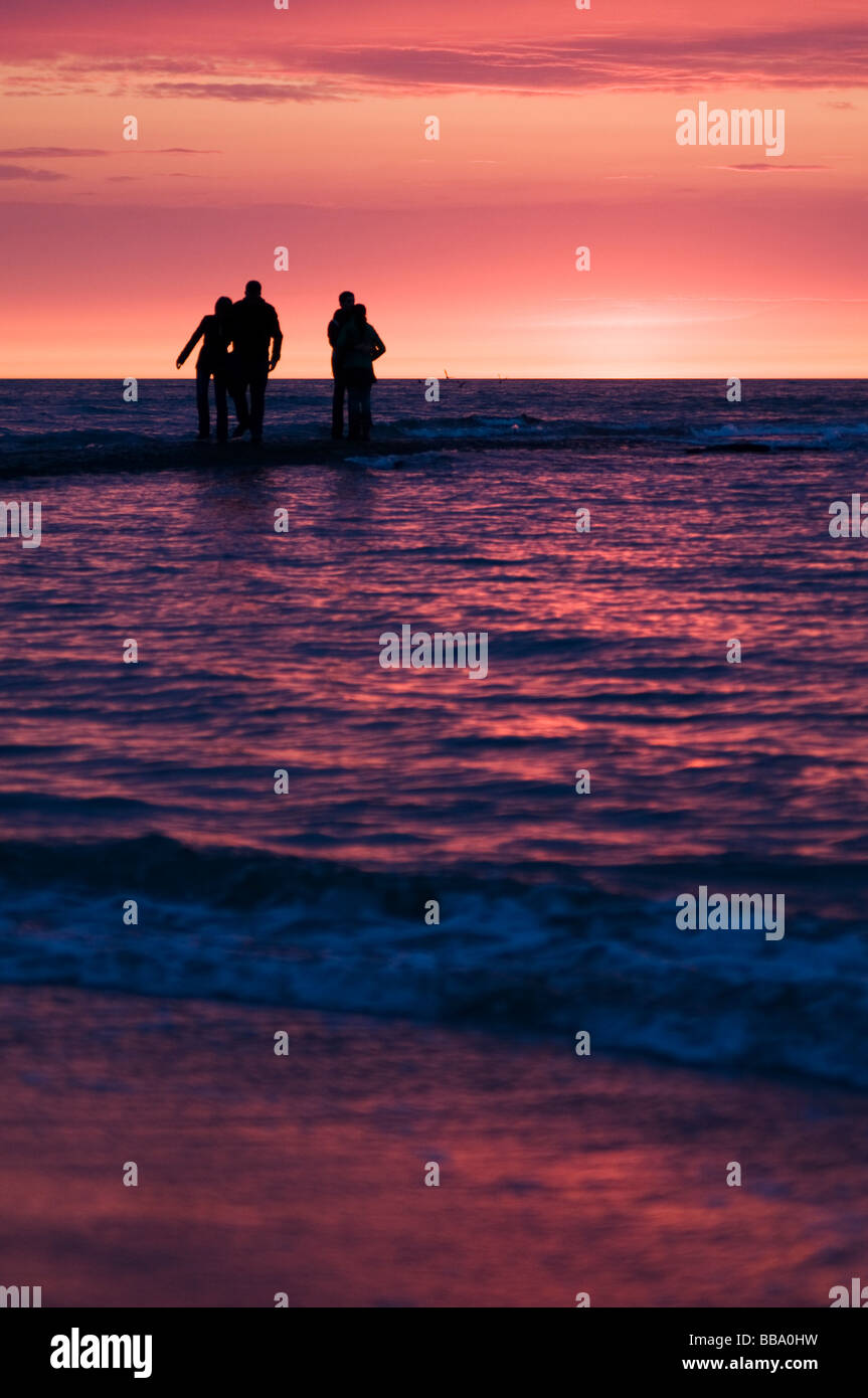 Des couples regardant le coucher du soleil sur la plage de Scheveningen, Den Haag, Pays-Bas Banque D'Images