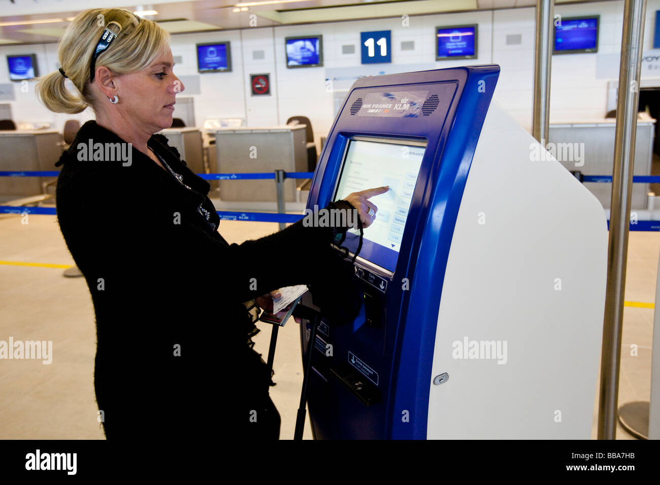 Femme au check-in-machine d'Air France et de KLM dans le hall des départs du Terminal 2, Aéroport de Paris-Charles de Gaulle, Paris, Franc Banque D'Images