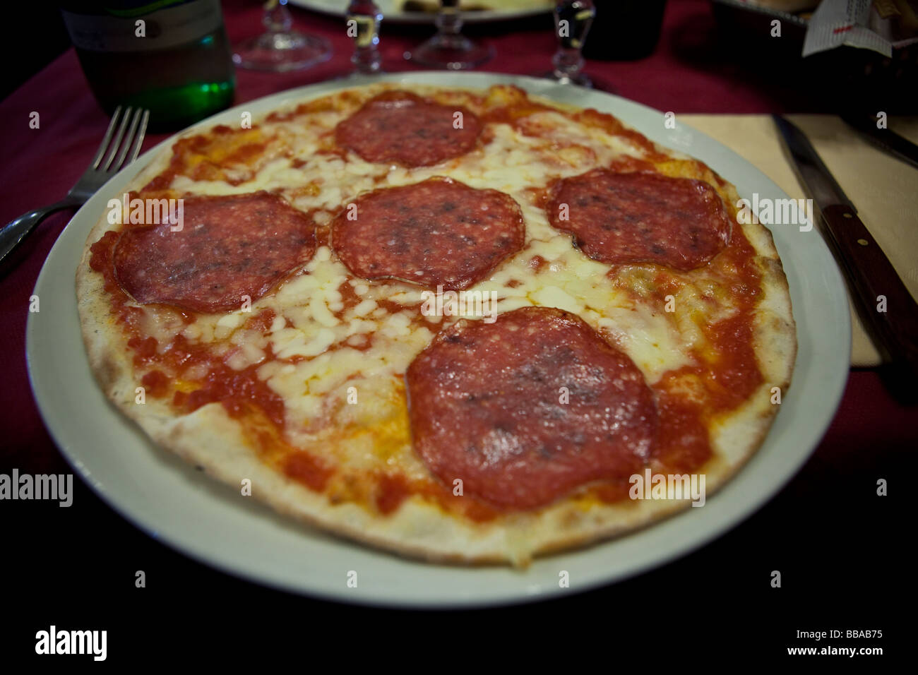 Pizza traditionnelle avec du fromage, pepperoni et les tomates dans un restaurant, Rome, Italie Banque D'Images