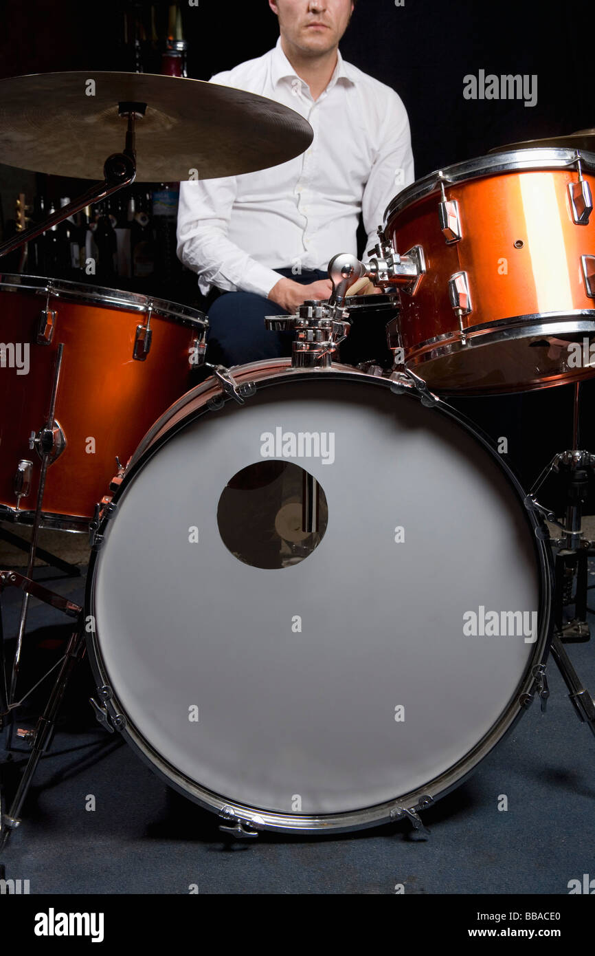 Un homme assis à un kit de batterie Banque D'Images