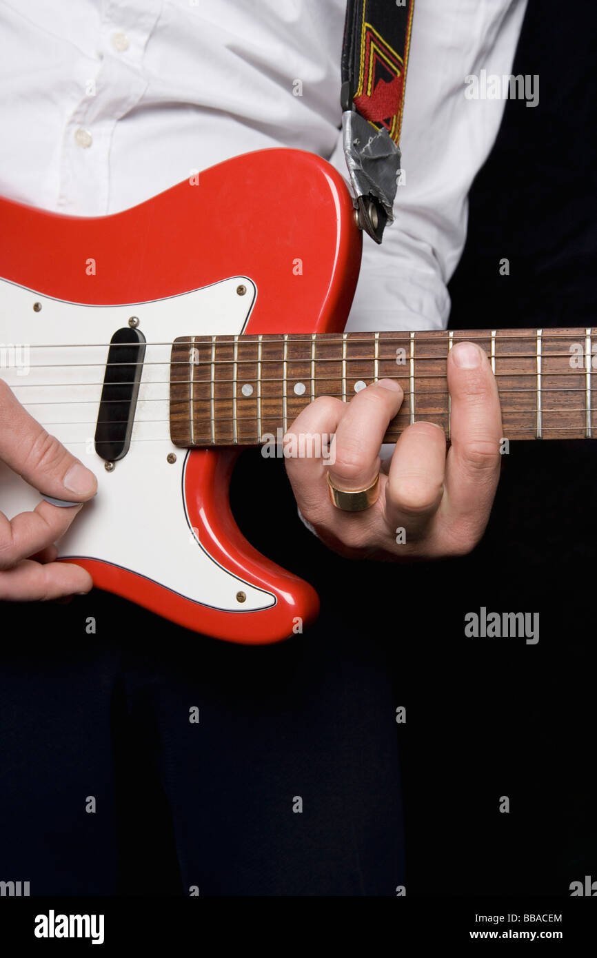 Détail d'un homme jouant d'une guitare électrique Banque D'Images