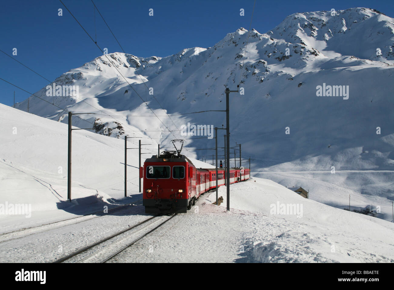 Train roulant à travers un col de montagne en hiver, Andermatt, Uri, Suisse Banque D'Images