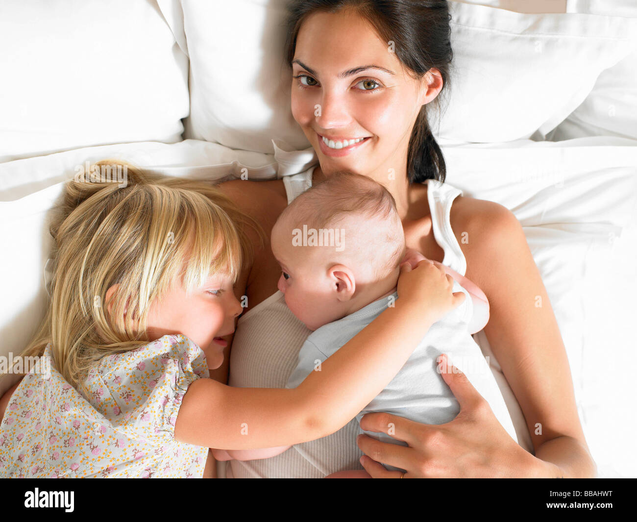 Mère avec des bébés au lit Banque D'Images