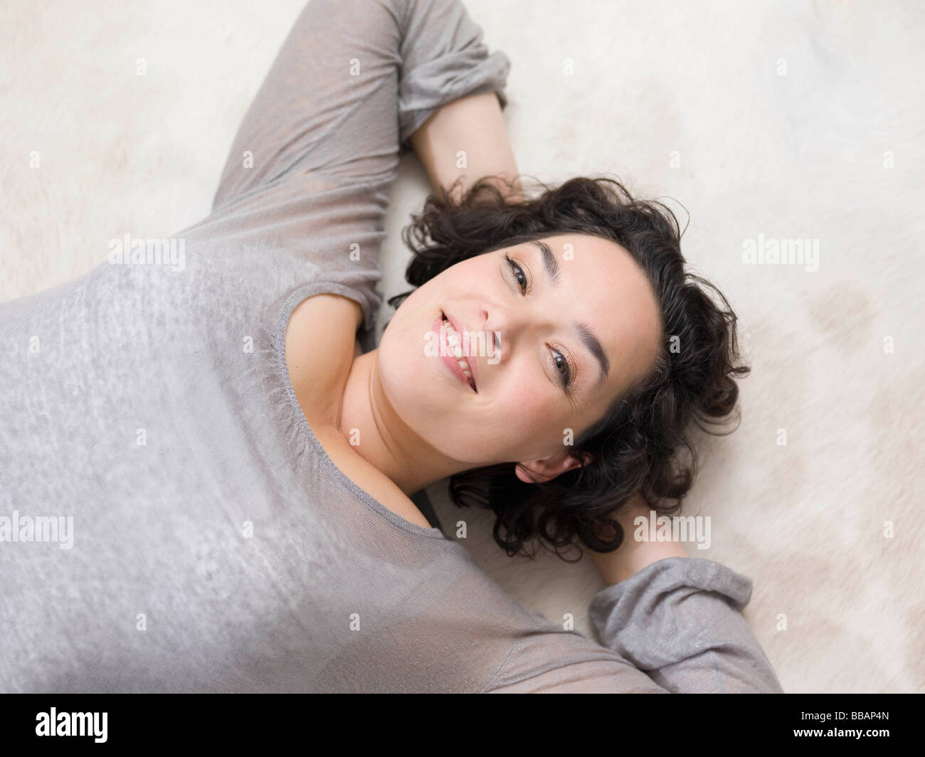 Une femme se détendre sur le plancher. Banque D'Images