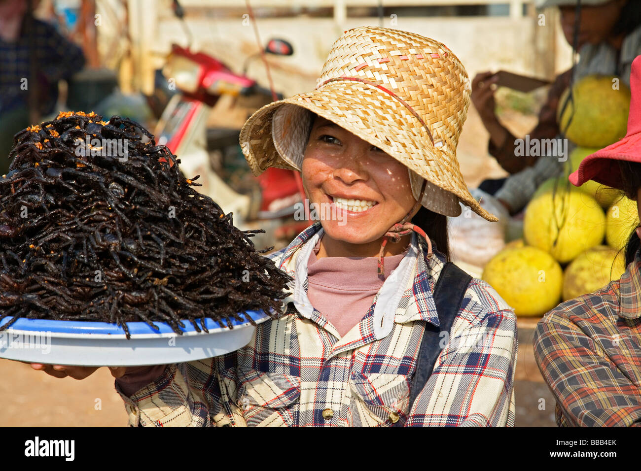 Femme vendant des Tarentules frites à Skuom marché sur la route entre Phnom Penh et Siem Reap Banque D'Images