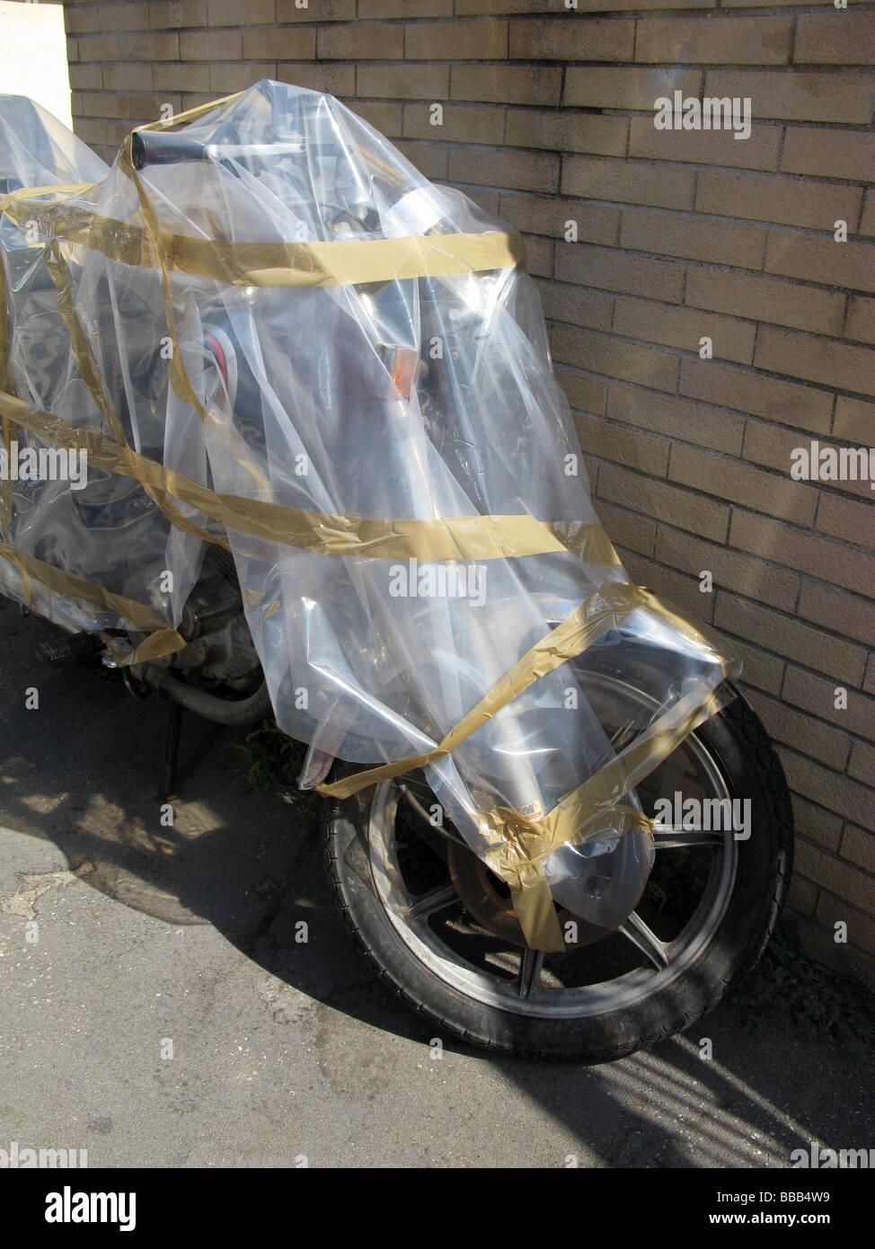 Une vieille moto couvert de feuille de plastique en polyéthylène dans  street road Photo Stock - Alamy