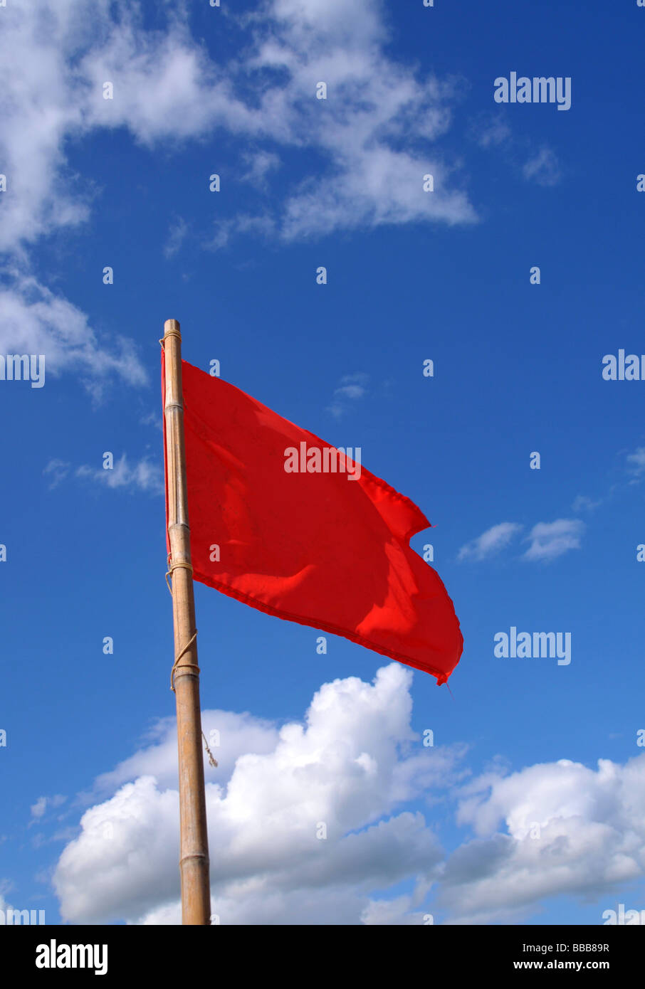 Un drapeau rouge dans le vent. Banque D'Images