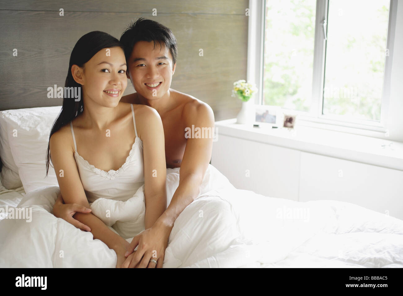 Couple assis dans son lit, looking at camera Banque D'Images