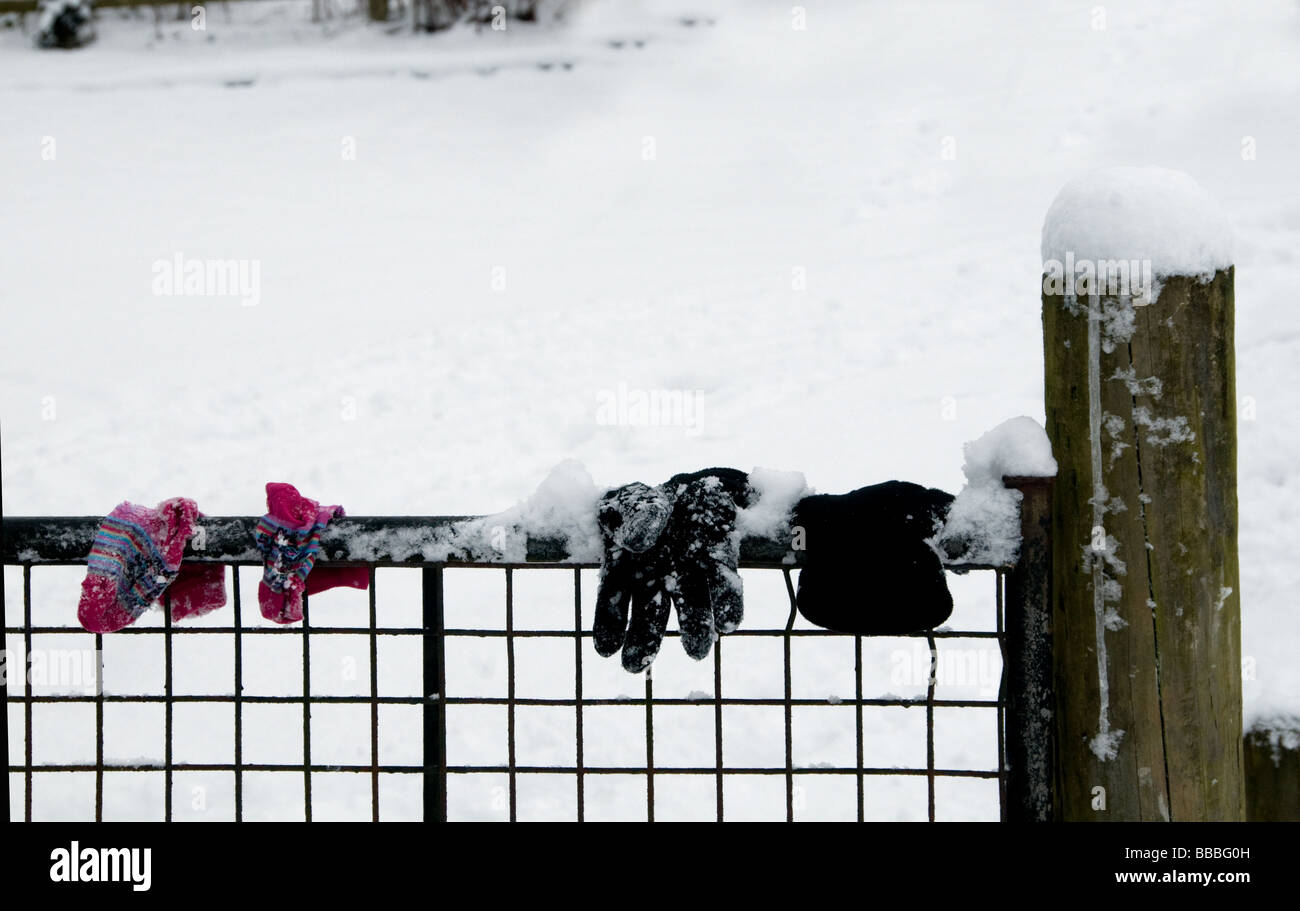 Les enfants quittent leurs gants de neige sur fence Banque D'Images