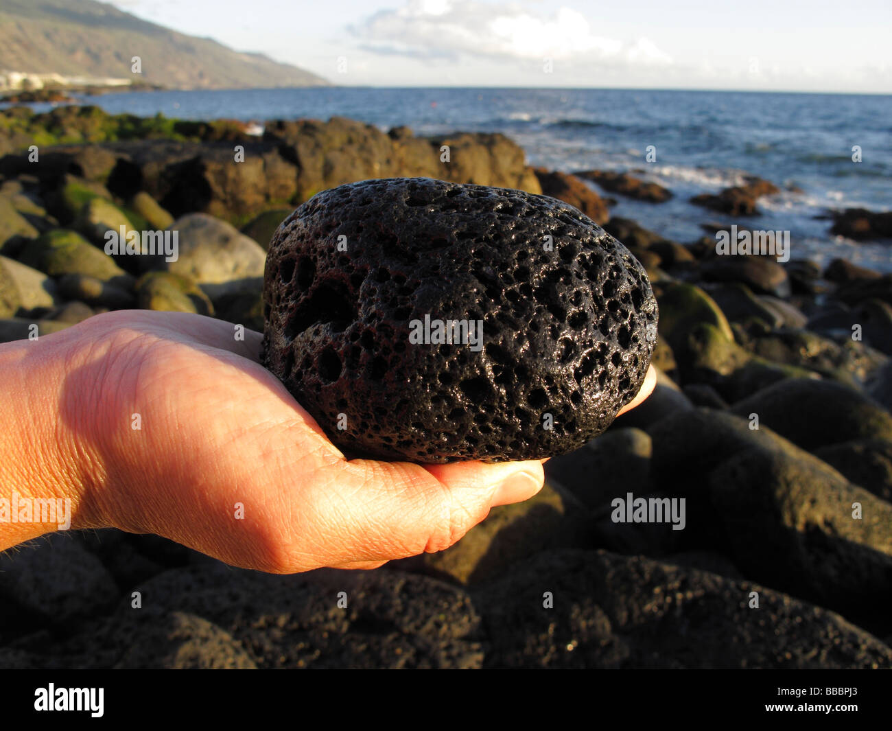 Main tenant la pierre de lave, sur la côte à La Palma, Îles Canaries, Espagne Banque D'Images