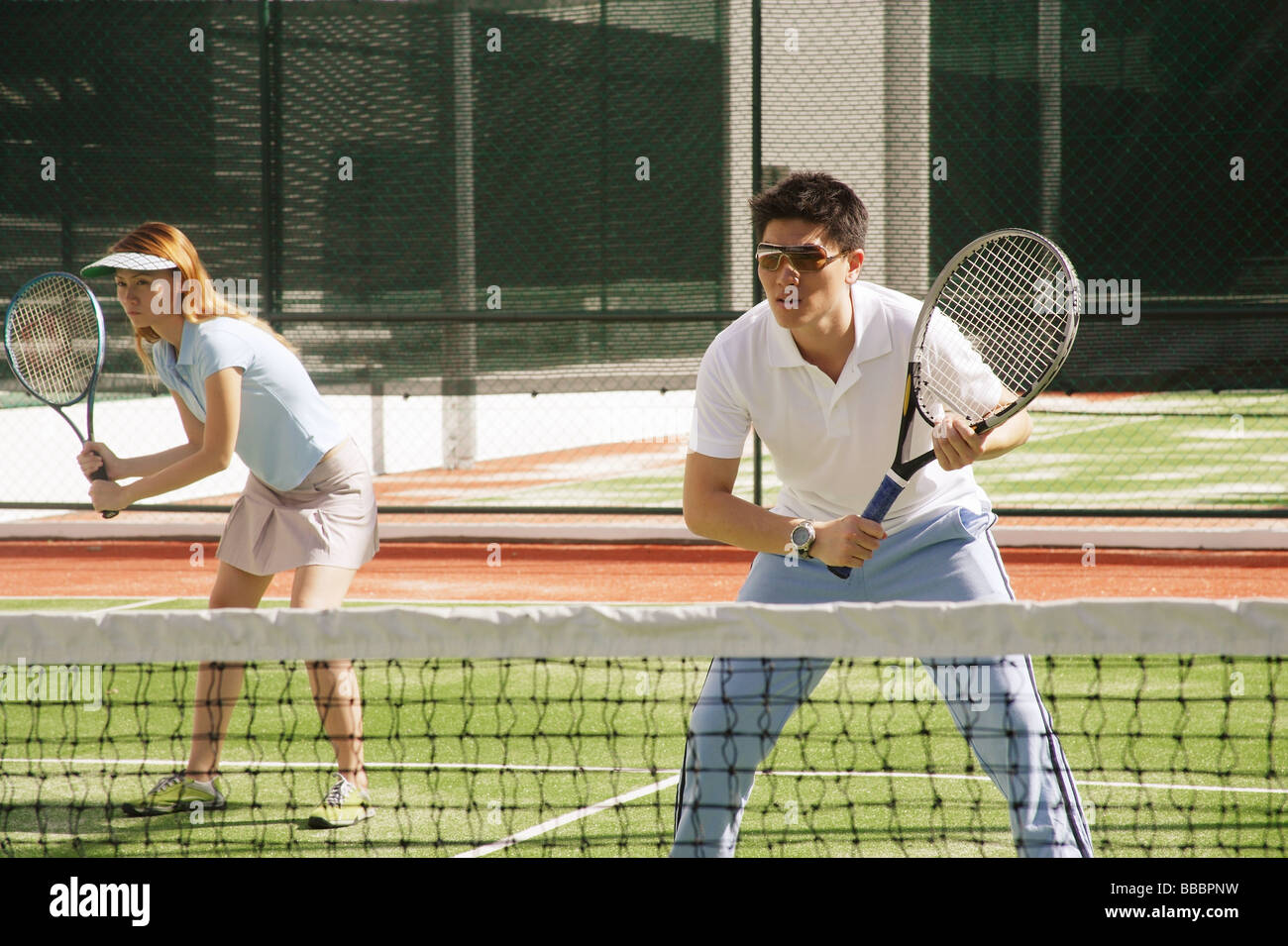 Couple de jouer à un jeu de tennis en double mixte Banque D'Images