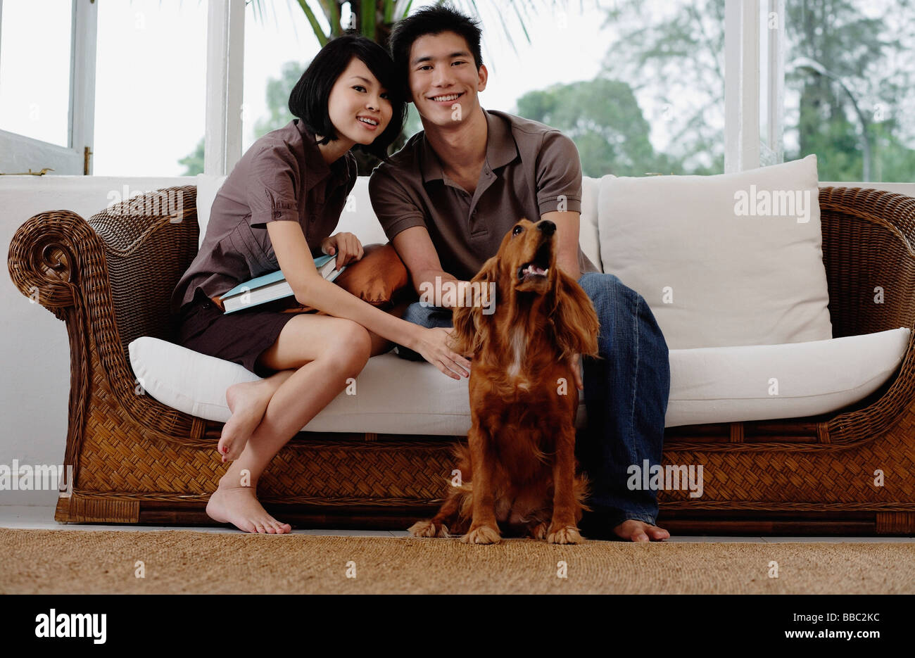 Un jeune couple avec un chien regarde l'appareil photo Banque D'Images
