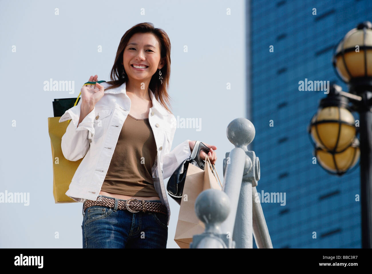 Woman carrying shopping bags, smiling Banque D'Images