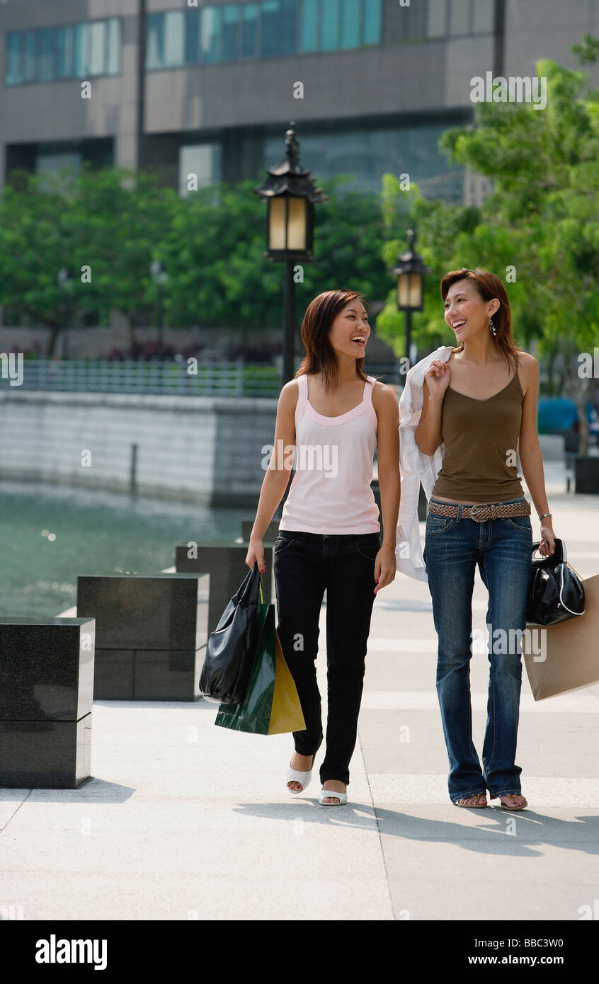 Deux femmes marchant côte à côte, carrying shopping bags Banque D'Images