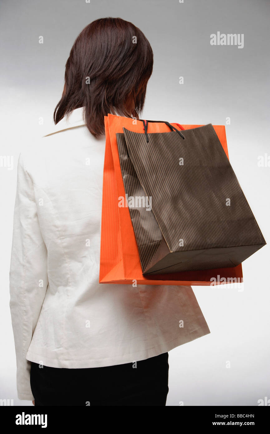 Woman carrying shopping bags, rétroviseurs Banque D'Images
