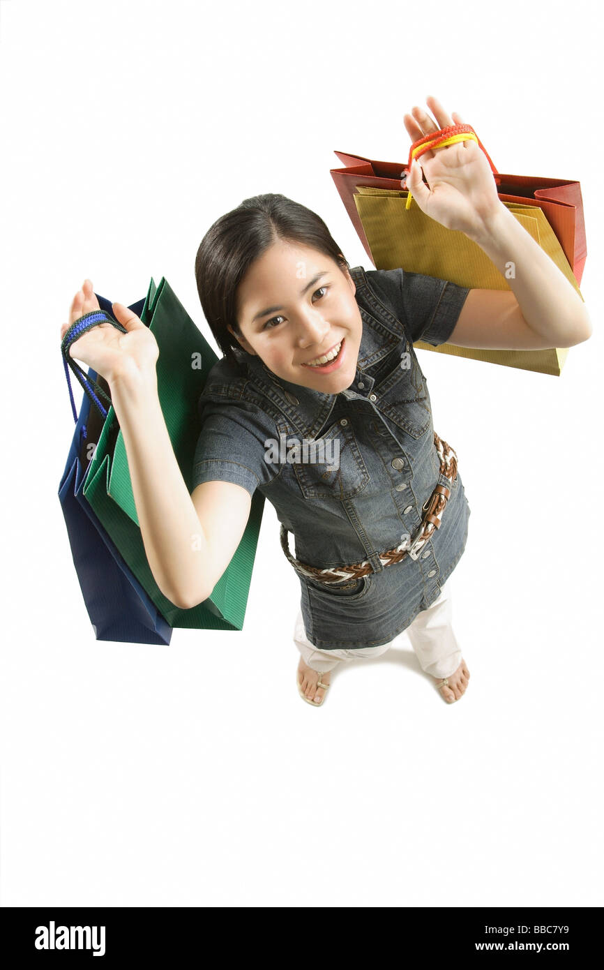 Young woman with shopping bags, smiling at camera Banque D'Images