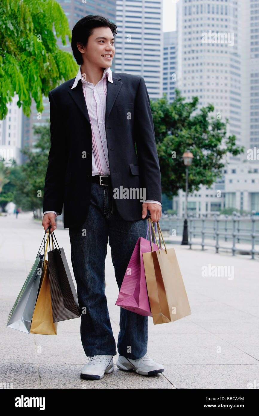 Homme debout avec les sacs, à l'écart Banque D'Images