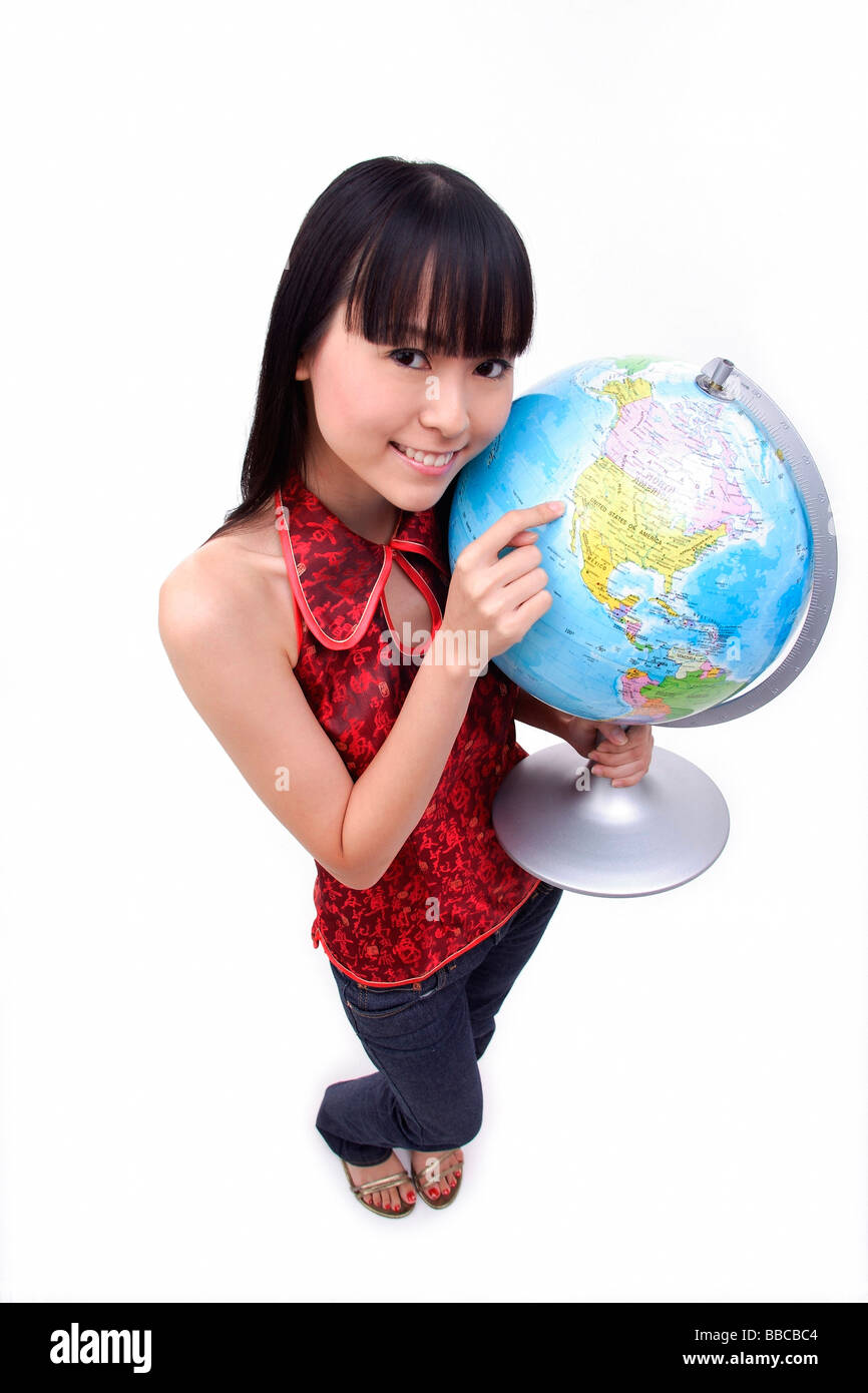 Woman pointing at globe Banque D'Images